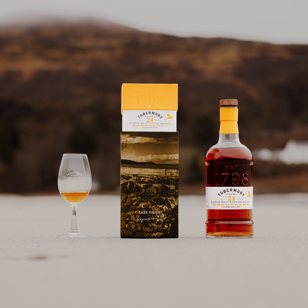 Hebridean Series 24 Year Old Bottle Pack and Dram on a Beach with Cliff Backdrop