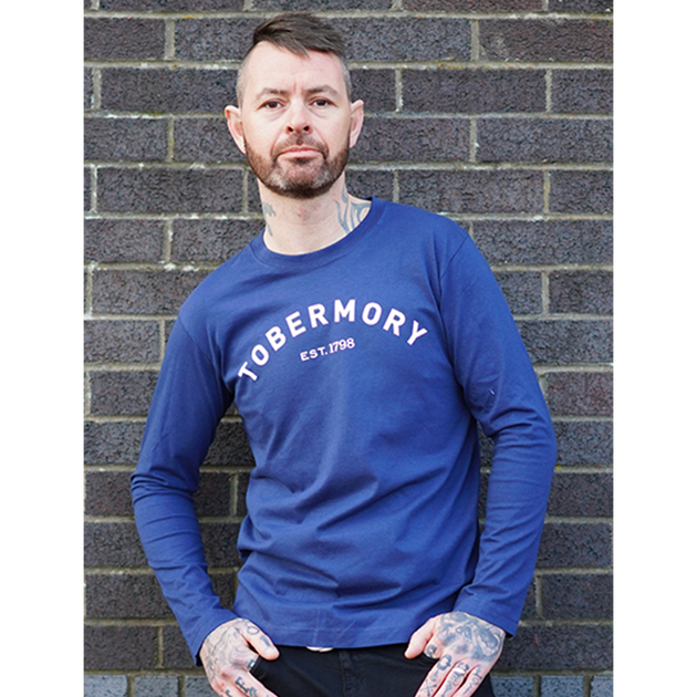 Tobermory whisky long sleeve top in blue on a male model. The top features Tobermory in Athletic style writing